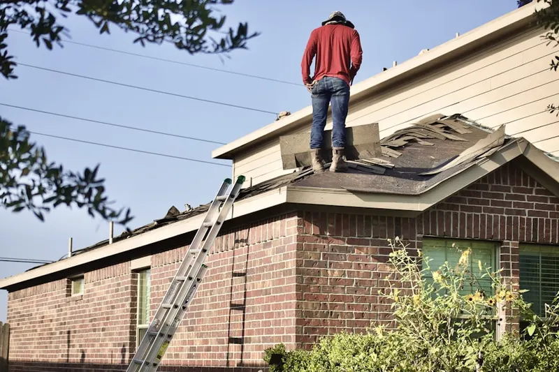 Professional roofer working on a residential roof in Albertson